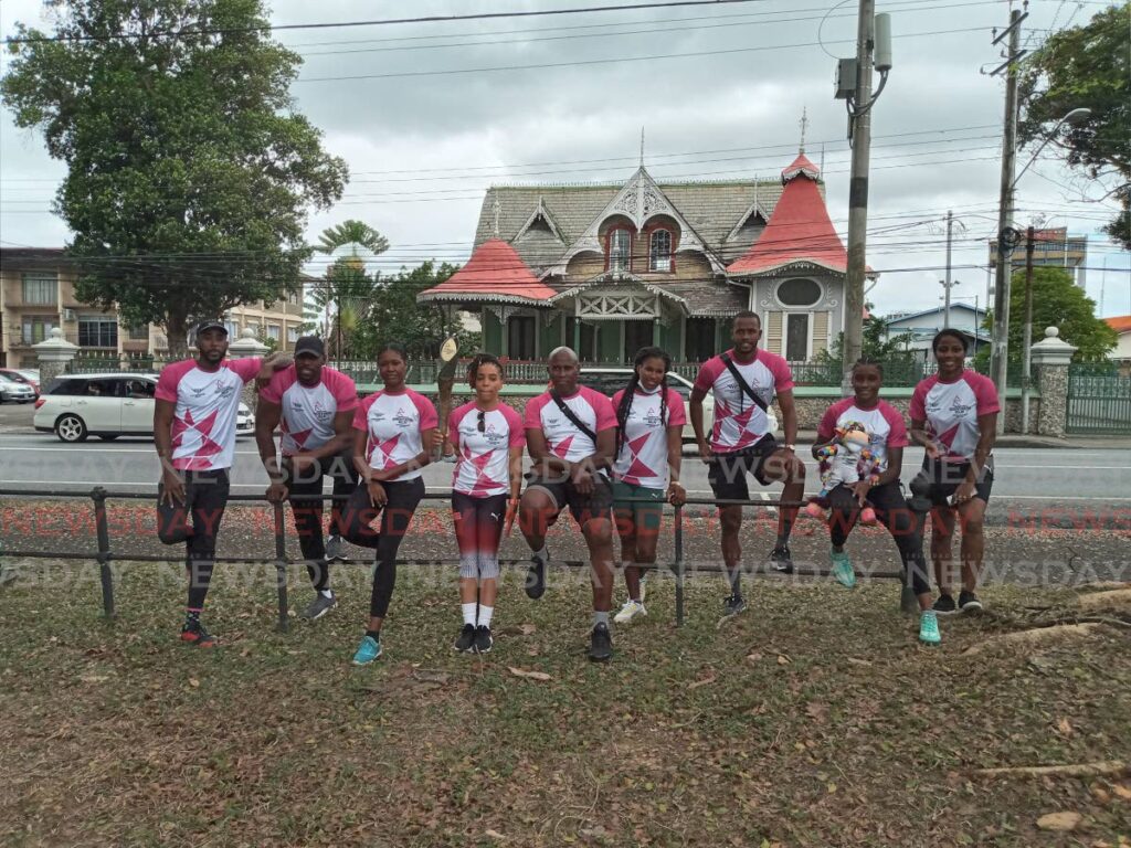 TT women’s boxer Tianna Guy, fourth from left, holds the Queen’s Baton at the Queen’s Park Savannah in Port of Spain, on Wednesday. She is joined by national athletes and former athletes. - Jelani Beckles