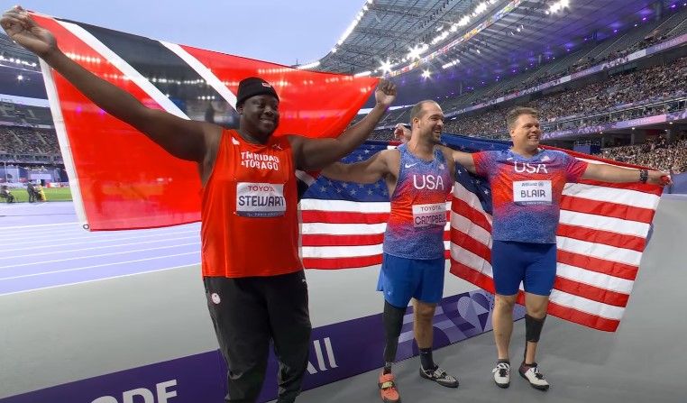 T&T Paralympian Akeem Stewart, left, celebrates after winning a silver medal in the Men’s F64 Discuss event at the 2024 Paris Paralympic Games in France, yesterday. The event’s winner was Jeremy Campbell of the USA, centre, while fellow American David Blair placed third. (Image obtained at guardian.co.tt)