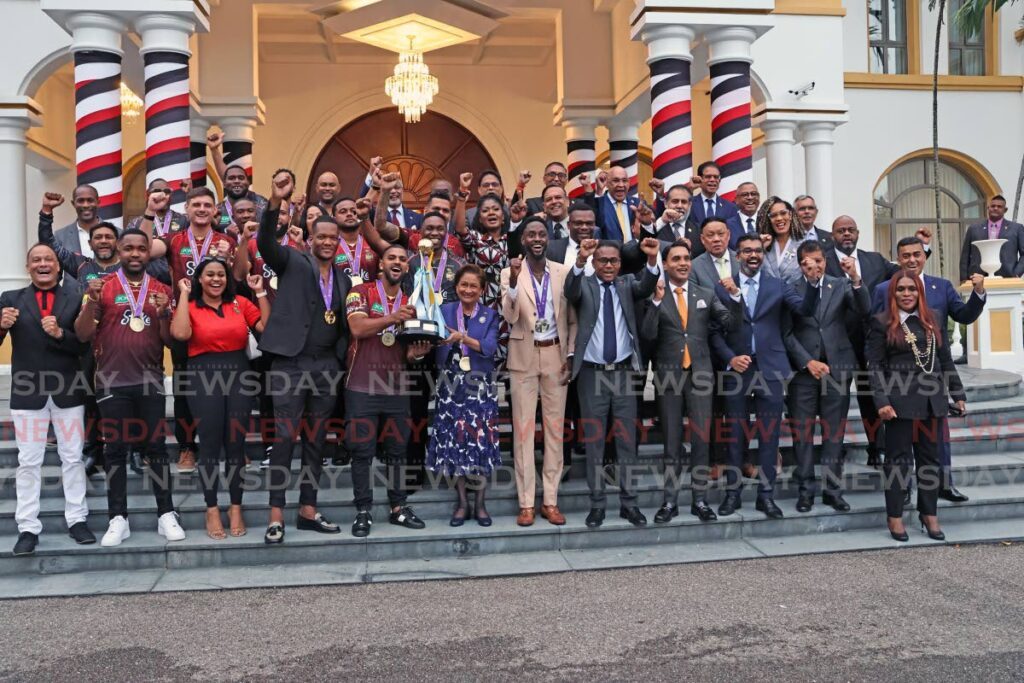 Prime Minister Kamla Persad-Bissessar, centre, and Trinbago Knight Riders captain Nicholas Pooran lift the 2025 Caribbean Premier League trophy, alongside World Championship gold medallist Keshorn Walcott, left, World Championship silver medallist Jereem Richards, second from right, and other Cabinet ministers and cricketers at the Diplomatic Centre, St Ann’s, on September 23. - Photo by Lincoln Holder (Image obtained at newsday.co.tt)